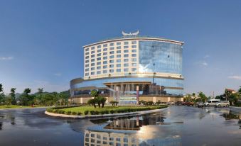 a large hotel building with a blue and white checkered facade is surrounded by water at Muong Thanh Luxury Son La