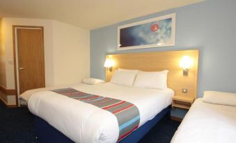 a hotel room with three beds , one on the left , one in the middle , and one on the right at Travelodge Ludlow Woofferton