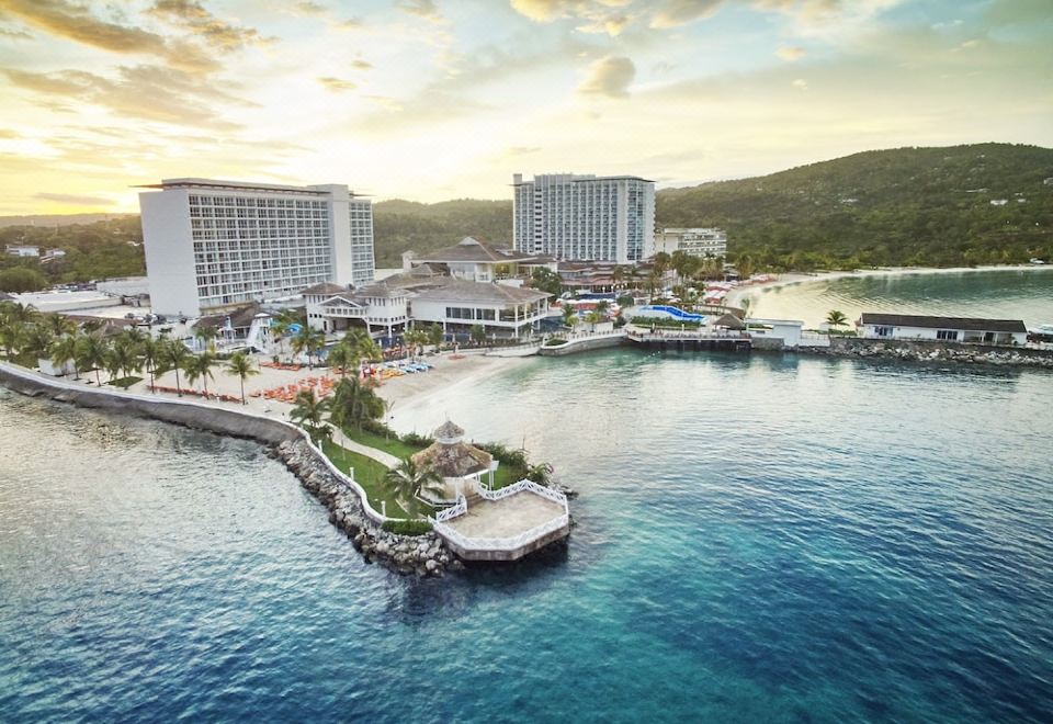 aerial view of a resort on the shore of a large body of water , with several buildings in the background at Moon Palace Jamaica