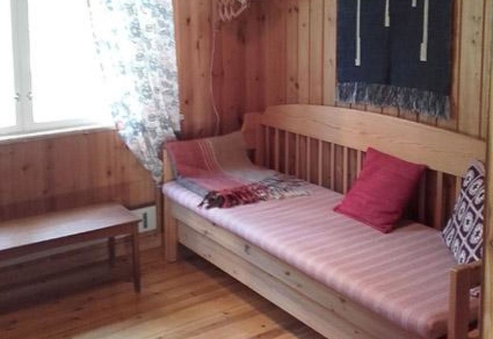a wooden bunk bed with a mattress on the bottom and a window on the top at Simola