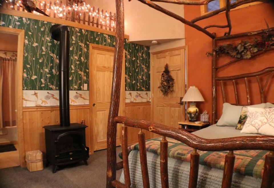 a cozy bedroom with a four - poster bed , a fireplace , and a christmas tree in the corner at Thyme for Bed