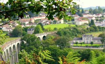 a picturesque rural landscape with a bridge spanning across a river , surrounded by lush green trees and hills at La Tulipe