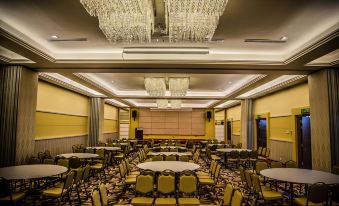 a large , well - lit banquet hall with numerous tables and chairs arranged for a formal event at Nova Highlands Hotel