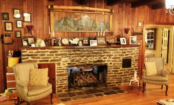 a cozy living room with a stone fireplace and wooden walls , creating a warm and inviting atmosphere at Grandview Lodge