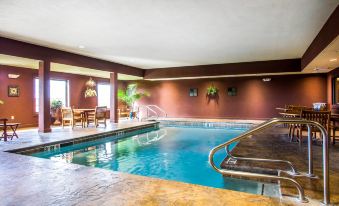 a large indoor swimming pool with a diving board and lounge chairs , surrounded by red walls at Comfort Inn & Suites Chillicothe