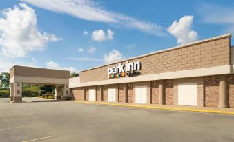 "a brick building with a parking garage entrance and a sign that reads "" park inn .""." at Ramada by Wyndham Uniontown