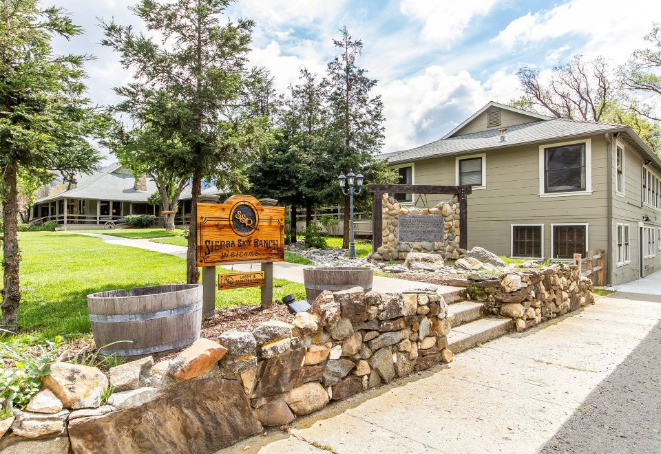 "a stone wall with a sign that says "" casa del borgo "" in front of a house" at Sierra Sky Ranch, Ascend Hotel Collection