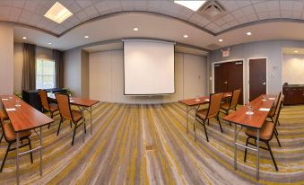 a conference room with chairs arranged in rows and a projector screen mounted on the wall at SpringHill Suites Pittsburgh Mills