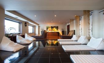 a large , modern living room with white furniture and black marble flooring , including couches and chairs at Lake Akan Tsuruga Wings