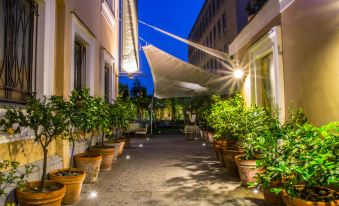 a courtyard with potted plants lining the walls , creating a serene and inviting atmosphere at night at Hotel Forum