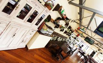 a dining area with wooden furniture , including a dining table and chairs , as well as potted plants at Alma