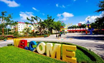 "a large welcome sign with the word "" welcome "" written on it , surrounded by grass and trees" at Legoland® Florida Resort