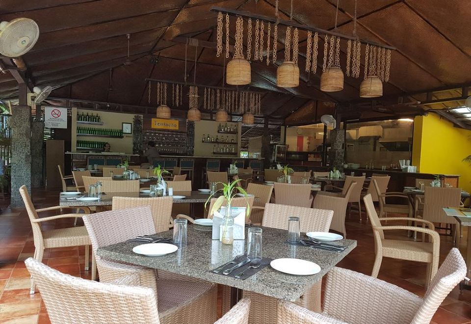 a restaurant with a dining area and tables , where several people are seated and enjoying their meals at Beleza by the Beach