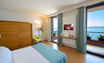 a modern hotel room with a large window , blue curtains , wooden furniture , and a bed at Hotel Eden