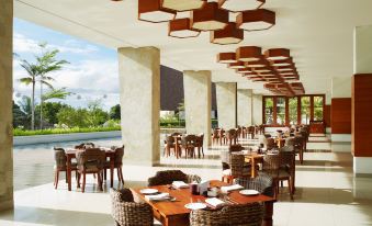 an outdoor dining area at a resort , with tables and chairs set up for guests to enjoy a meal at MERUSAKA Nusa Dua
