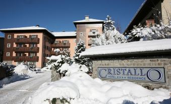 "a hotel with a snow - covered front entrance and a sign that reads "" cristallos hotel & residence "" in front of a building" at Hotel Cristallo