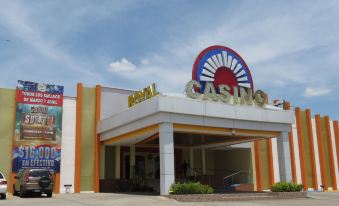 "a large , orange and white building with a sign that reads "" casino "" prominently displayed on it" at Hotel La Hacienda