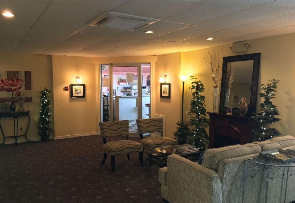 a hotel lobby with several chairs and couches , as well as a christmas tree in the background at Fairway Inn