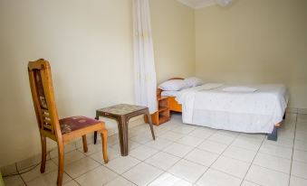 a clean and well - organized bedroom with a bed , a chair , and a table in the room at Collin Hotel