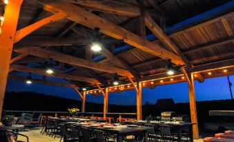 an outdoor dining area with wooden beams , tables , and chairs set up for a group of people to enjoy a meal at Hill Country Casitas