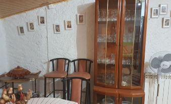 a dining room with a wooden table , chairs , and a glass cabinet filled with dishes at Casa Rural la Plazuela de Mari