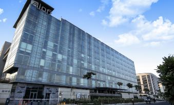 "a large , modern building with a large glass facade and the word "" aire "" on it" at Aloft New Delhi Aerocity