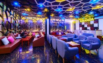 a modern lounge area with blue and red furniture , surrounded by geometric patterns on the ceiling at Amanda Hotel