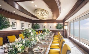 a long dining table with chairs , surrounded by potted plants and flowers , creating a warm and inviting atmosphere at Sheraton Grande Tokyo Bay Hotel