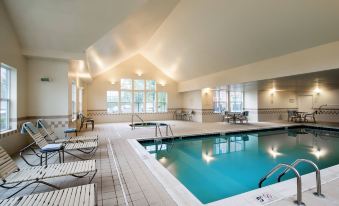 an indoor swimming pool surrounded by chairs and tables , providing a relaxing atmosphere for guests at Residence Inn Philadelphia Langhorne