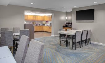 a modern , well - equipped kitchen with a dining area and a tv mounted on the wall at Residence Inn Richmond Chester