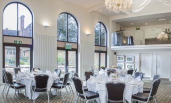 a large dining room with multiple tables set for a formal event , featuring elegant chairs and a chandelier at New Place