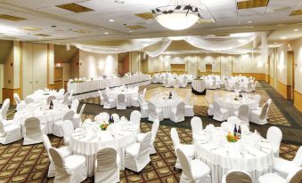 a large banquet hall is set up with white tablecloths and chairs , all set up for a formal event at Deer Creek Lodge & Conference Center