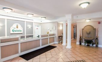 a hotel lobby with a check - in desk and a reception area , as well as several chairs and tables at Country Inn & Suites by Radisson, Hoffman Estates, IL