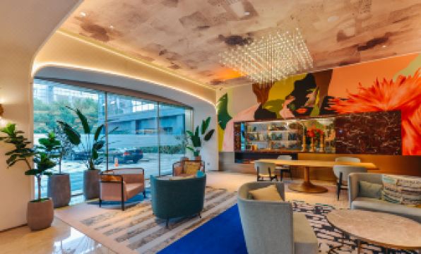 The hotel lobby features an open concept design with chairs and tables arranged along the wall at Mercure Shanghai Hongqiao SOHO