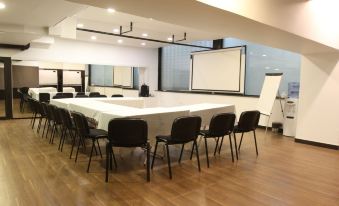 a conference room with a long white table and several chairs arranged for a meeting at Hamra Urban Gardens
