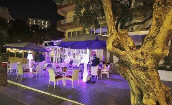 an outdoor dining area with tables and chairs set up for a party or gathering at Alegria