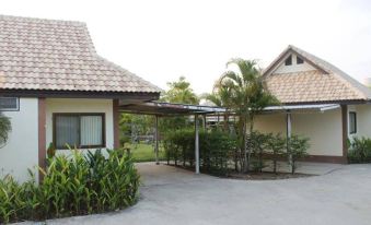 a house with a patio and a covered area , surrounded by greenery and surrounded by plants at Saraburi Garden Resort