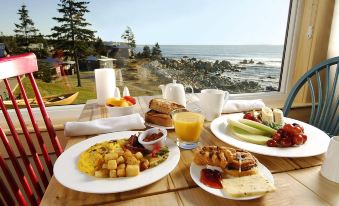 a dining table with a delicious breakfast laid out , consisting of various types of food and beverages at White Point Beach Resort