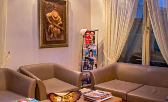 a cozy living room with two couches , a coffee table , and a painting on the wall at Oxford Hotel