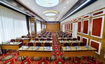 a large conference room with rows of chairs arranged in a semicircle , and a podium at the front of the room at New Marathon Hotel