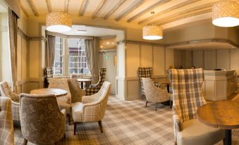 a cozy living room with several chairs and couches arranged around a coffee table , creating a comfortable and inviting atmosphere at The Stair Arms Hotel