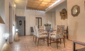 a dining room with a table and chairs , surrounded by a carpeted floor and a ceiling with a light fixture at La Torre