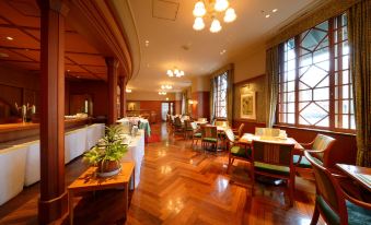 a spacious restaurant with wooden floors , large windows , and a dining area filled with tables and chairs at Hotel JAL City Aomori