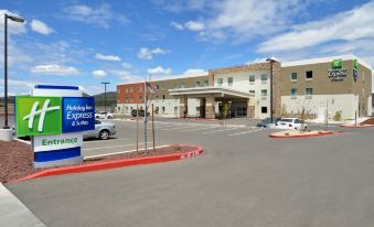 a large parking lot in front of a building , with several cars parked and a sign for the business at Holiday Inn Express & Suites Williams