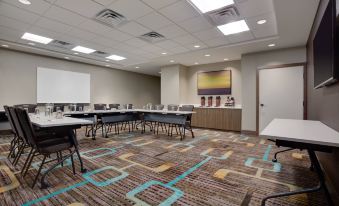 a conference room with a long table , chairs , and a large screen on the wall at Residence Inn Kingston