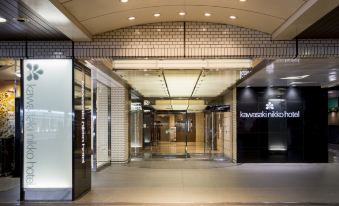 "a modern building entrance with brick walls and glass doors , featuring a sign for "" jatosauna "" above it" at Kawasaki Nikko Hotel