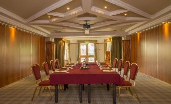 a conference room with a long table set up for a meeting , surrounded by chairs at Bunratty Castle Hotel