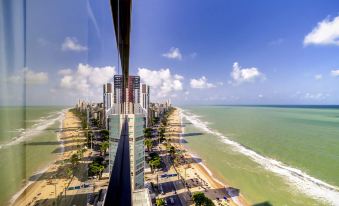 a panoramic view of a city skyline with tall buildings and a body of water at Grand Mercure Recife Boa Viagem