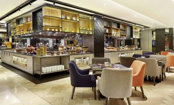 a restaurant with a dining area , where several people are seated and enjoying their meals at Novotel Jakarta Mangga Dua Square