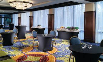 a hotel lobby with several tables and chairs set up for a meeting or event at Atlanta Airport Marriott